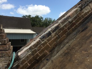 Repointing bricks on the roof of a historic building on a plantation